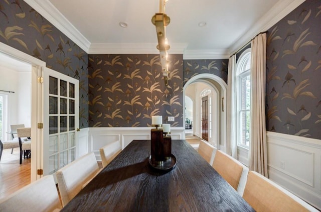 663 Clifton Rd NE, Atlanta, GA 30307 - unfurnished dining area featuring wallpapered walls, arched walkways, healthy amount of natural light, crown molding, and a wainscoted wall