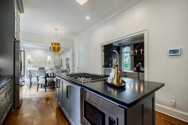 663 Clifton Rd NE, Atlanta, GA 30307 - kitchen featuring stainless steel appliances, dark countertops, dark wood-style floors, crown molding, and hanging light fixtures