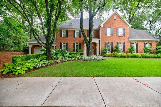 663 Clifton Rd NE, Atlanta, GA 30307 - colonial inspired home featuring brick siding, a front yard, a garage, and a shingled roof