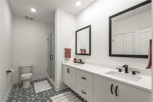 bathroom with tile patterned floors, vanity, toilet, and a shower with shower door