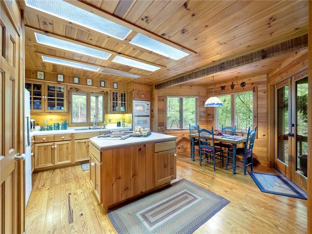 kitchen with white appliances, wood ceiling, wood walls, and a center island