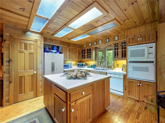 kitchen featuring white appliances, light wood-type flooring, wood walls, wooden ceiling, and a kitchen island