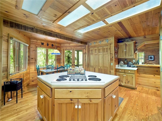 kitchen with wooden walls, a kitchen island, wood ceiling, and light hardwood / wood-style floors