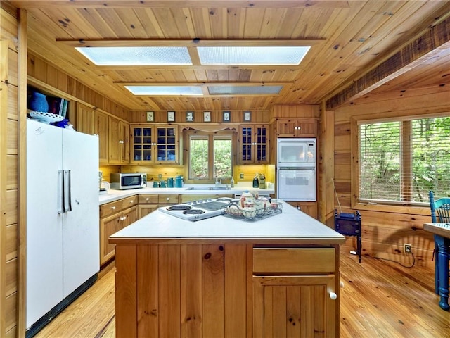 kitchen featuring light wood-type flooring, white appliances, wood ceiling, and a kitchen island