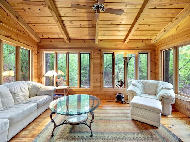 living room featuring ceiling fan, vaulted ceiling with beams, and a healthy amount of sunlight