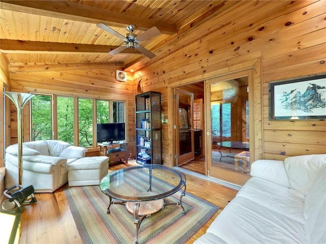 living room with light hardwood / wood-style floors, vaulted ceiling with beams, wooden walls, ceiling fan, and wood ceiling