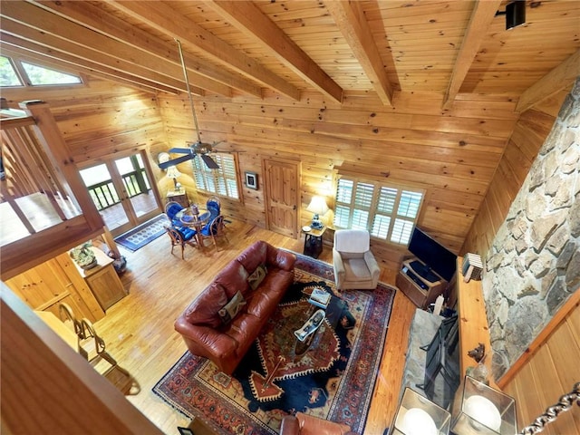 unfurnished living room featuring lofted ceiling with beams, wood walls, and wooden ceiling