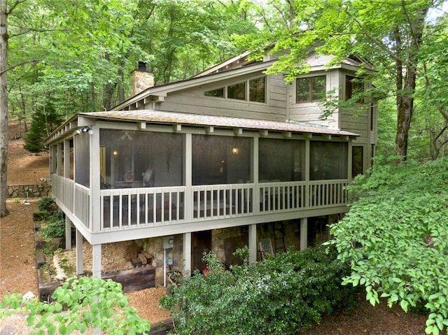 back of property with a sunroom