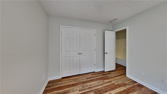 145 Charleston Pl, Covington, GA 30016 - unfurnished bedroom with visible vents, baseboards, wood finished floors, and a closet