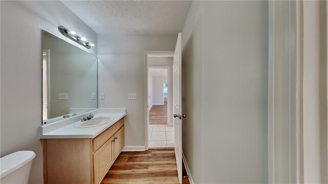 145 Charleston Pl, Covington, GA 30016 - bathroom featuring wood finished floors, toilet, vanity, and a textured ceiling