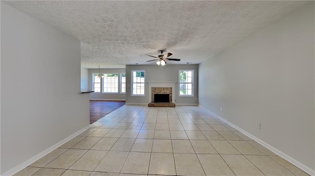 145 Charleston Pl, Covington, GA 30016 - unfurnished living room with baseboards, a ceiling fan, a textured ceiling, and light tile patterned floors