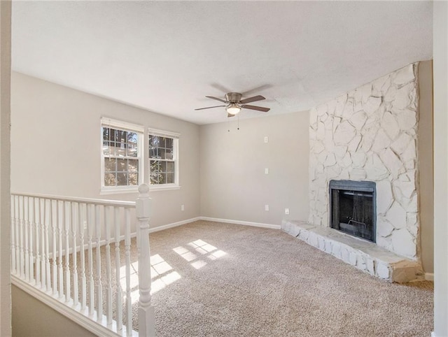 unfurnished living room featuring carpet flooring, ceiling fan, and a fireplace