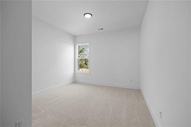 unfurnished room featuring baseboards and light colored carpet