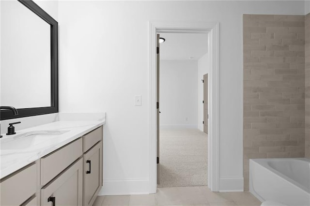 bathroom with baseboards, tile patterned floors, a bath, and vanity