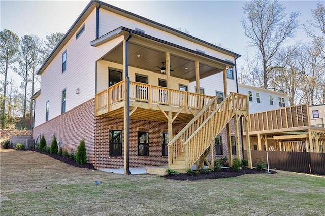 rear view of house featuring fence, brick siding, stairway, cooling unit, and a ceiling fan
