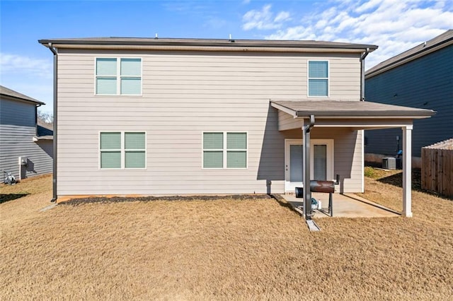 rear view of property featuring a yard, a patio, and central AC