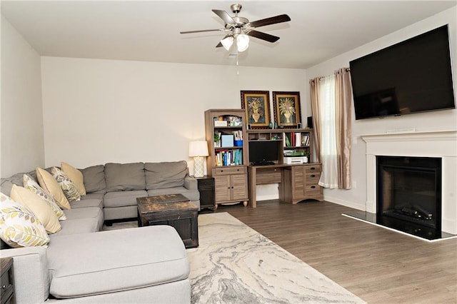 735 Sweethaven Ln, Loganville, GA 30052 - living room featuring wood finished floors, ceiling fan, and a fireplace with raised hearth