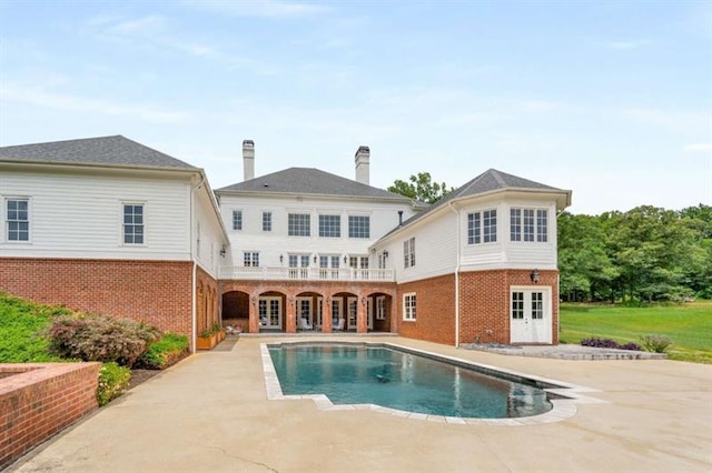 833 Hines Rd, Moreland, GA 30259 - back of property with french doors, brick siding, a patio, and an outdoor pool