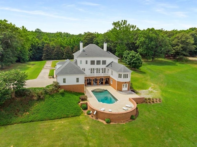 833 Hines Rd, Moreland, GA 30259 - rear view of property with a patio area, a lawn, an outdoor pool, a view of trees, and a chimney