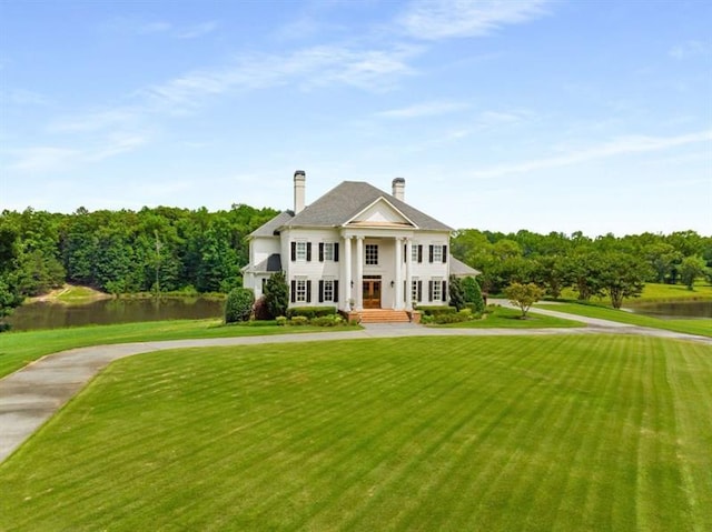 833 Hines Rd, Moreland, GA 30259 - neoclassical home featuring a front yard, a water view, concrete driveway, and a chimney