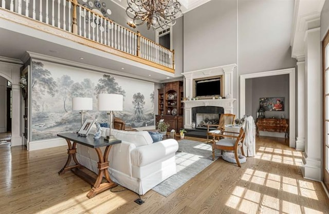 833 Hines Rd, Moreland, GA 30259 - living room with a high ceiling, wood finished floors, a fireplace with raised hearth, a chandelier, and ornamental molding