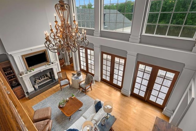 833 Hines Rd, Moreland, GA 30259 - living room with french doors, a chandelier, wood finished floors, a towering ceiling, and plenty of natural light