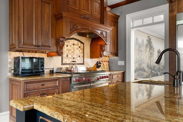 833 Hines Rd, Moreland, GA 30259 - kitchen with range with two ovens, crown molding, light stone countertops, backsplash, and brown cabinets