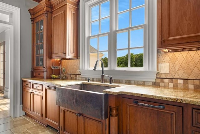 833 Hines Rd, Moreland, GA 30259 - kitchen with brown cabinets, decorative backsplash, light stone countertops, and glass insert cabinets