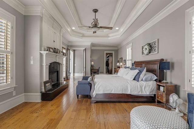 833 Hines Rd, Moreland, GA 30259 - bedroom featuring multiple windows, light wood-type flooring, a fireplace with raised hearth, ceiling fan, and crown molding