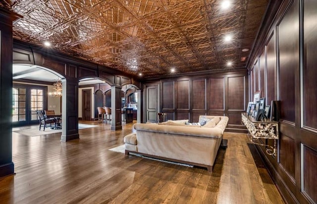 833 Hines Rd, Moreland, GA 30259 - living area with arched walkways, decorative columns, a decorative wall, dark wood-style floors, and crown molding