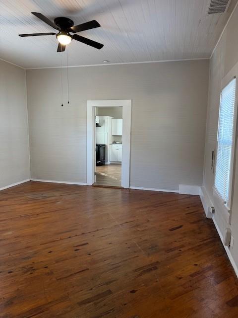 unfurnished room featuring ceiling fan, dark wood-type flooring, and ornamental molding