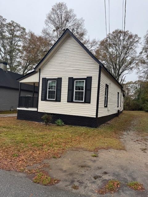 view of property exterior with a lawn and covered porch