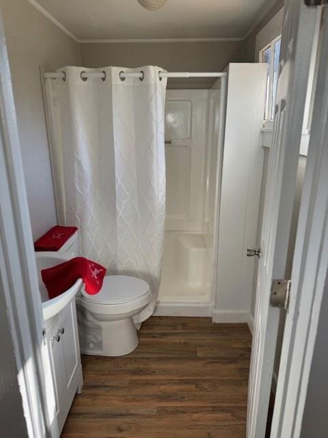 bathroom featuring a shower with shower curtain, vanity, crown molding, wood-type flooring, and toilet