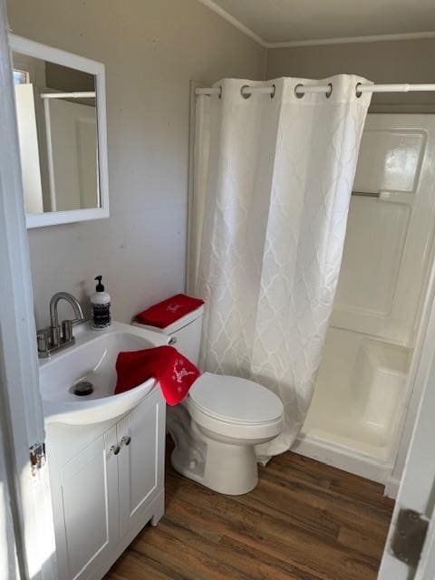 bathroom with crown molding, toilet, hardwood / wood-style flooring, vanity, and a shower with shower curtain