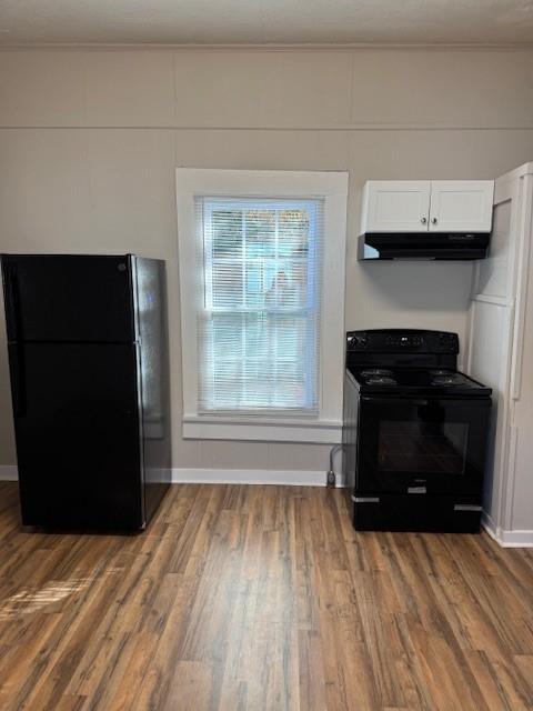 kitchen featuring ornamental molding, white cabinets, black appliances, and wood-type flooring