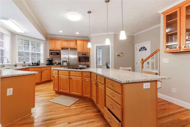 kitchen with a kitchen island, stainless steel appliances, and light wood-type flooring