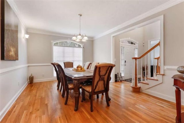 dining area with light hardwood / wood-style flooring, a notable chandelier, and ornamental molding