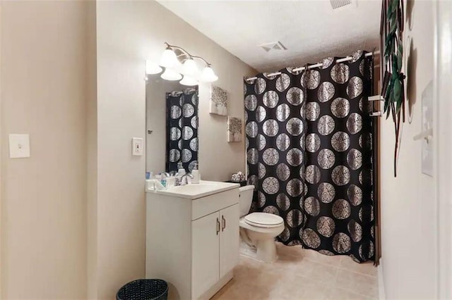 bathroom with tile patterned flooring, vanity, and toilet