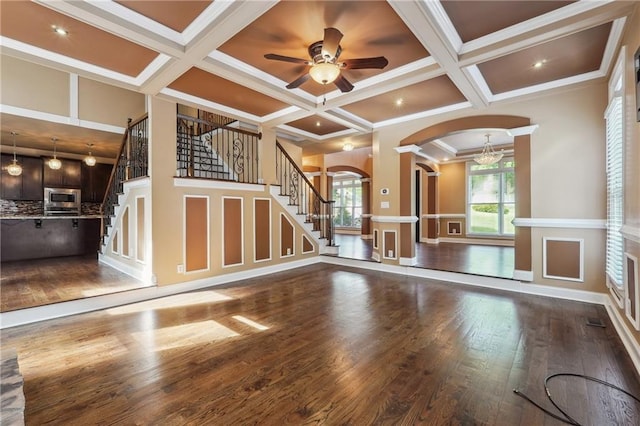 unfurnished living room featuring ornamental molding, a healthy amount of sunlight, coffered ceiling, and beamed ceiling