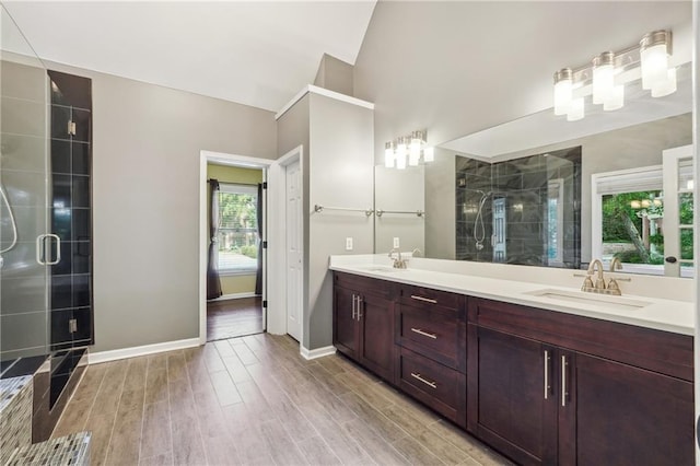 bathroom featuring a shower with shower door and vanity