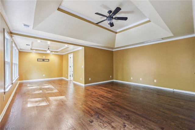 empty room with ornamental molding, ceiling fan, a tray ceiling, and hardwood / wood-style flooring