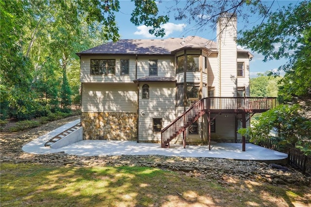 rear view of house featuring a wooden deck and a patio