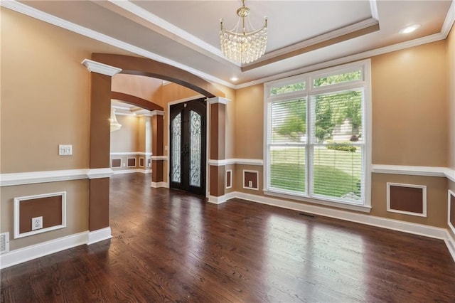 empty room featuring ornamental molding, a wealth of natural light, and a tray ceiling