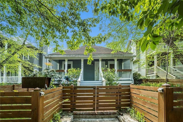 bungalow-style house featuring fence and roof with shingles
