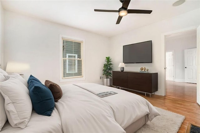 bedroom with wood finished floors, baseboards, and a ceiling fan