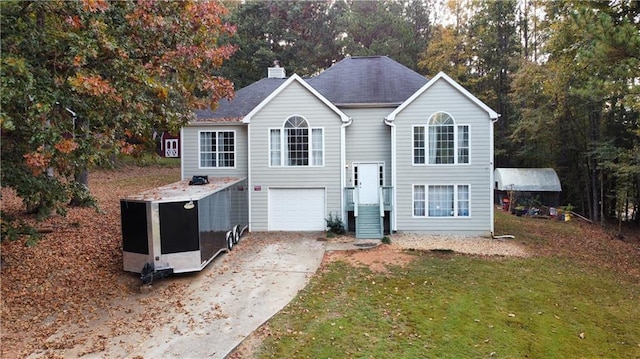 raised ranch featuring a garage and a front lawn