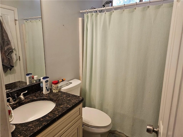 bathroom featuring curtained shower, vanity, and toilet