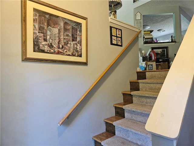 stairway with a textured ceiling