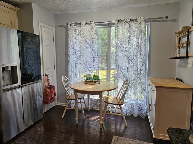 dining room featuring dark wood-type flooring and a textured ceiling