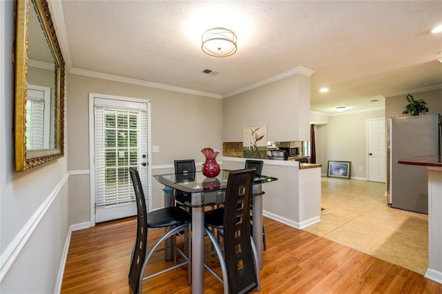 3645 Shrewsbury Ct, Snellville, GA 30039 - dining space featuring crown molding, light wood-style flooring, and a textured ceiling